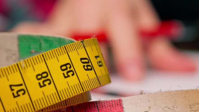 close-up in sewing workshop of a colored centimeter against which something is written