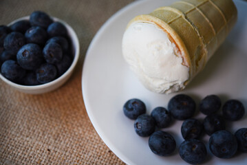 Creamy ice cream and blueberries on a white plate. Blueberry ice cream.