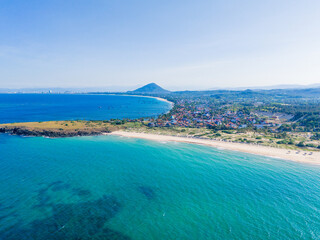 Naklejka premium Aerial view of Bai Xep beach in Phu Yen province, Vietnam. Tropical coast from cliff above. Vietnam travel destination, golden sand beach waving sea rock boulders.