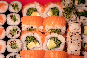 Salmon and avocado urumaki and maki sushi, cucumber, sesame seeds