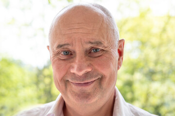 close-up charismatic mature man, senior 65 years old smiles joyfully, skin folds, age-related skin changes, aesthetic injection cosmetology, care anti-aging procedures