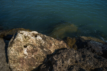 Serene waters meet rugged rocks in a tranquil dance of nature elements, ideal for themes of peace, strength, and the enduring spirit of the natural world