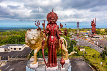 A powerful Statue of the Hindu goddess Durga Maa with a golden lion in sacred Ganga Talao. Shiva...