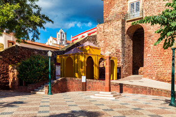 Fototapeta premium View of Silves town buildings with a red and white archway and a blue fountain, Algarve region, Portugal.