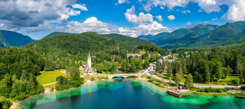 Aerial view of Bohinj lake in Julian Alps. Popular touristic destination in Slovenia. Bohinj Lake, Church of St John the Baptist. Triglav National Park, Julian Alps, Slovenia.