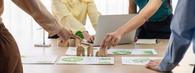 Wooden block represented green city and wind mill represented renewable energy was placed at center...