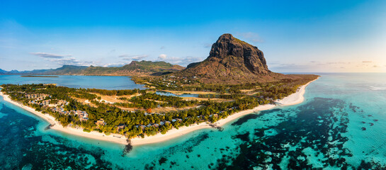 Beach with palm trees and umbrellas on Le morne beach in Mauriutius. Luxury tropical beach and Le Morne mountain in Mauritius. Le Morne beach with palm trees, white sand and luxury resorts, Mauritius