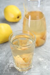Delicious quince drink and fresh fruits on grey table, closeup