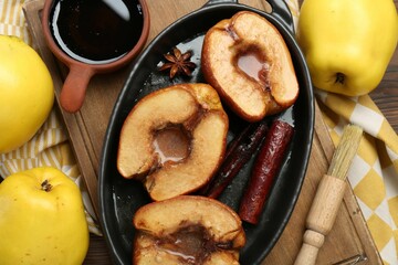 Tasty baked quinces served with sauce on table, flat lay