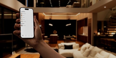 Hand holding a phone with a blank screen against a home interior
