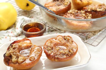Fototapeta premium Delicious quinces baked with honey and walnuts on white table