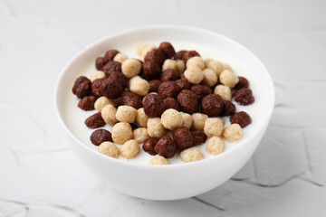 Breakfast cereal. Tasty corn balls with milk in bowl on white textured table, closeup
