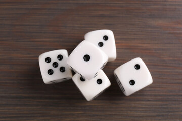 Many white game dices on wooden table, top view