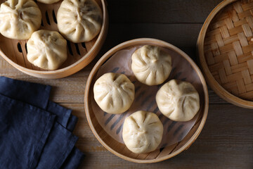 Delicious bao buns (baozi) on wooden table, flat lay