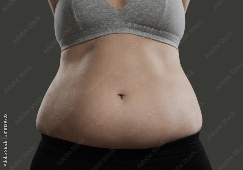 Poster Woman with excessive belly fat on grey background, closeup. Overweight problem