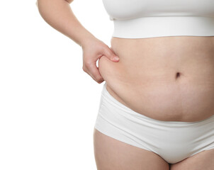 Woman touching belly fat on white background, closeup. Overweight problem