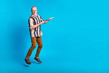 Photo of glad funky nice smiling man wear striped stylish clothes jump up blank space isolated on...