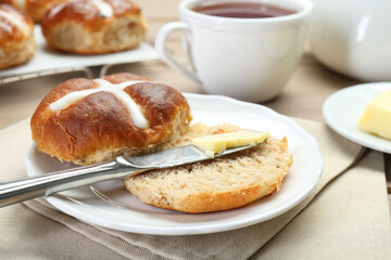 Tasty hot cross bun served on table, closeup