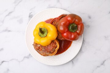 Delicious stuffed bell peppers served on white marble table, top view