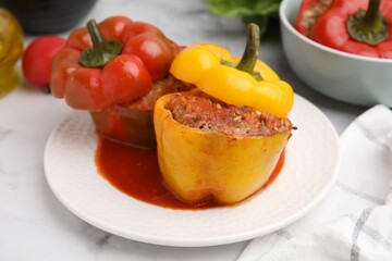 Delicious stuffed bell peppers served on white marble table