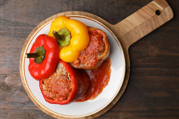 Delicious stuffed bell peppers served on wooden table, top view