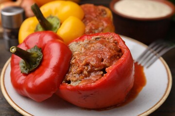 Delicious stuffed bell peppers served on wooden table, closeup