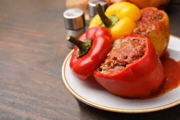 Delicious stuffed bell peppers served on wooden table, closeup. Space for text