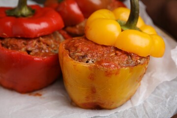 Delicious stuffed bell peppers served on table, closeup