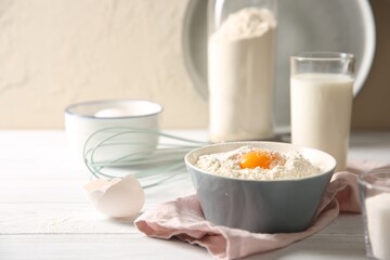 Making dough. Flour with yolk in bowl on white wooden table, closeup