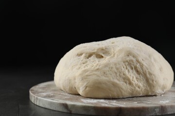 Raw homemade dough on black table, closeup