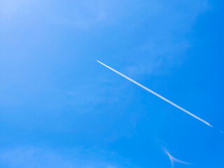 Photo image of a plane passing through the blue sky