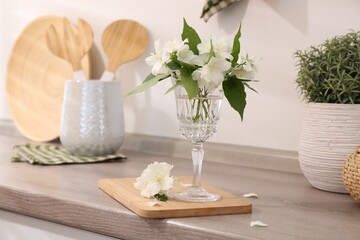 Beautiful jasmine flowers on wooden table indoors