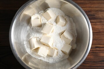 Making shortcrust pastry. Flour and butter in bowl on wooden table, top view