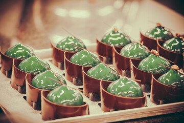 Green glazed tartlets with chocolate. Prepared tartlets to be finished by a professional pastry chef.