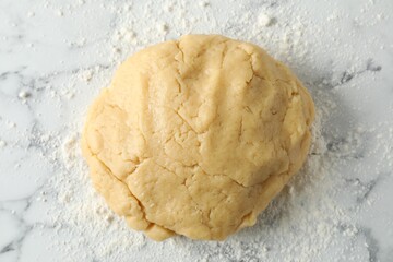 Making shortcrust pastry. Raw dough and flour on white marble table, top view
