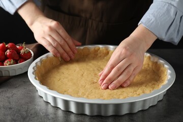 Shortcrust pastry. Woman making pie at grey table, closeup
