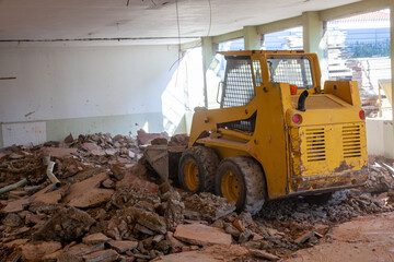 A compact bulldozer clears rubble at a renovation site, showcasing its efficiency and power in...