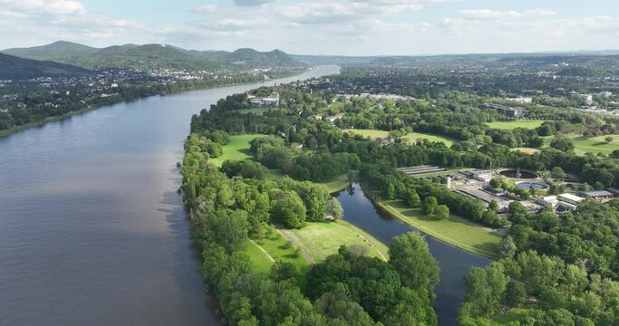 Aerial drone view of the city of Bonn, Germany looking over the Freizeitpark Rheinaue along the rhine river in summer time