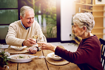 Senior couple, wine and cheers on table to celebrate anniversary date, dinner or lunch at home....