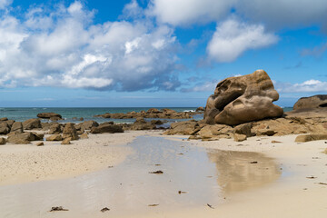 Des rochers massifs parsemant une plage le long de la Côte des Légendes de Bretagne, imprégnée de mystère et de légendes.
