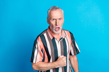 Photo of angry mad senior man wear striped stylish clothes shout scream loud talk isolated on blue color background