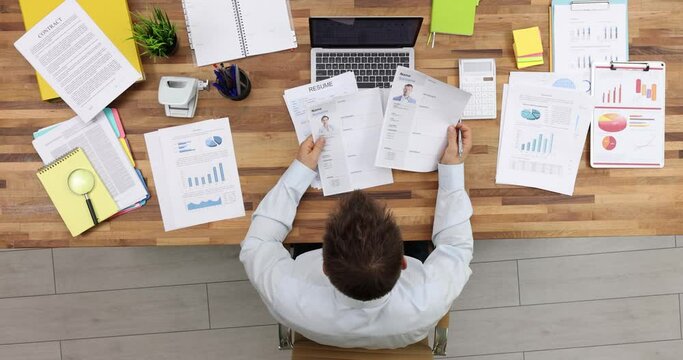 HR manager studies vacancy candidates resumes at workplace. Businessman chooses talents for commercial company department. Personnel application