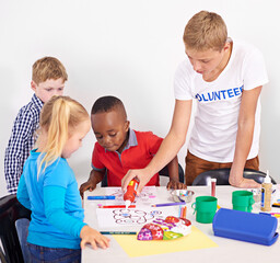 Teamwork, volunteer and children together playing in daycare for development, learning and fun....