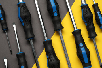 Set of screwdrivers on color background, flat lay