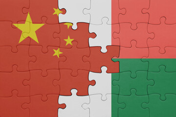 puzzle with the colourful national flag of madagascar and flag of china .