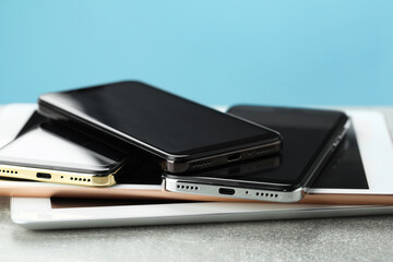 Stack of electronic devices on grey table, closeup
