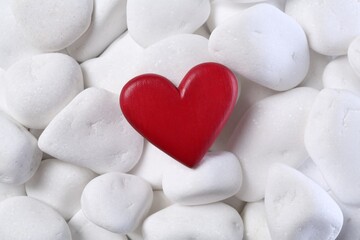 Decorative heart on white pebble stones, top view