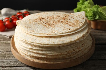 Stack of tasty homemade tortillas on wooden table