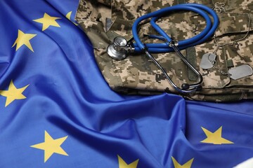 Stethoscope and military uniform on flag of European Union, closeup