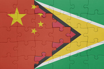 puzzle with the colourful national flag of guyana and flag of china .